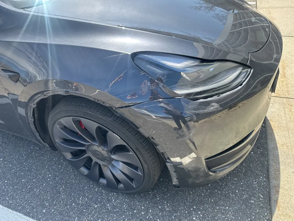 Damaged front fender on a Tesla before repair