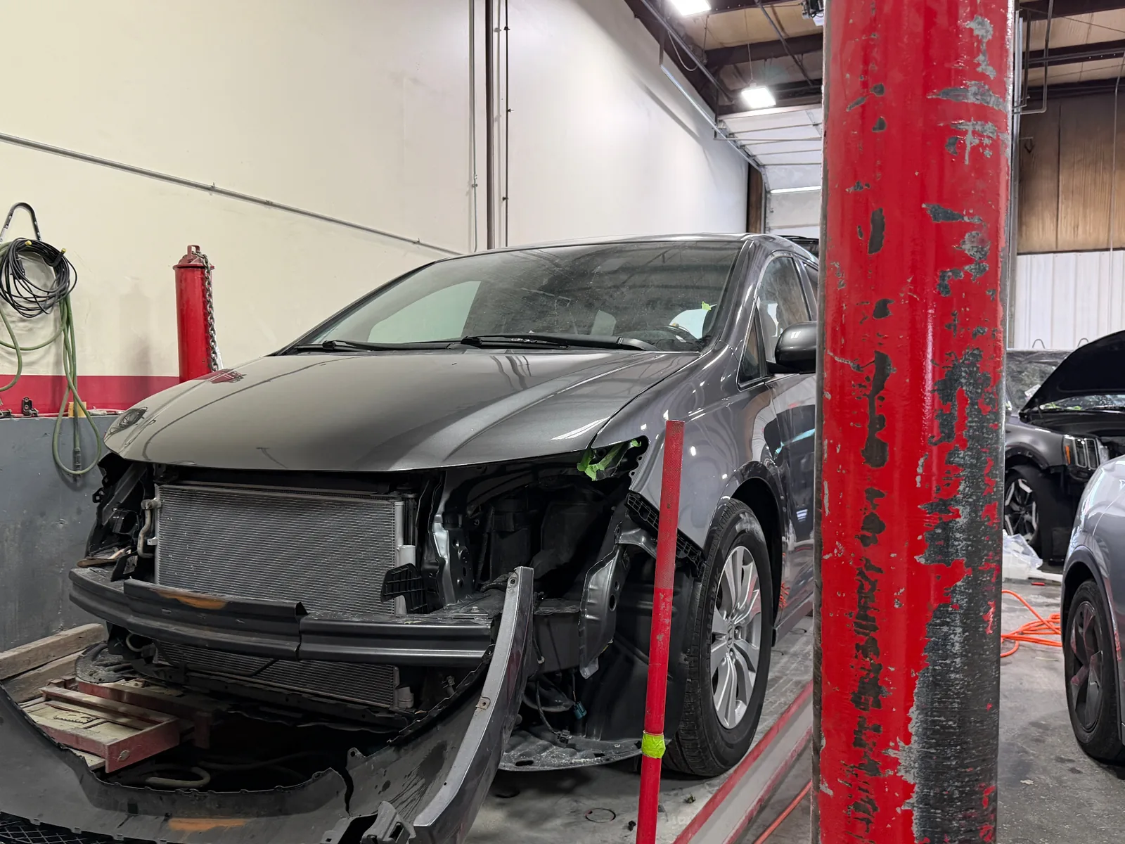 Vehicle mid-repair with front end disassembled in the Best Finish shop